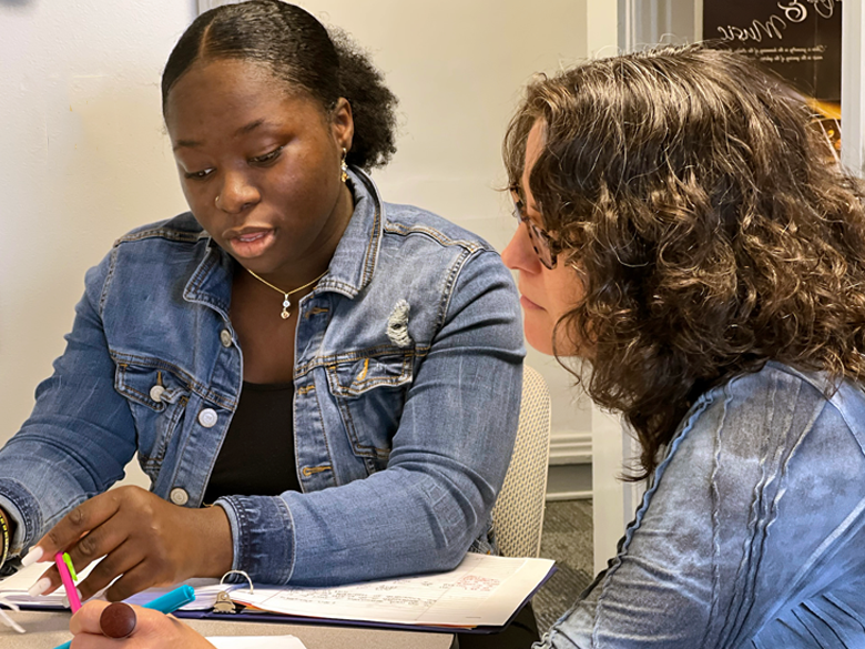 photo of a white female faculty member working with a black female student